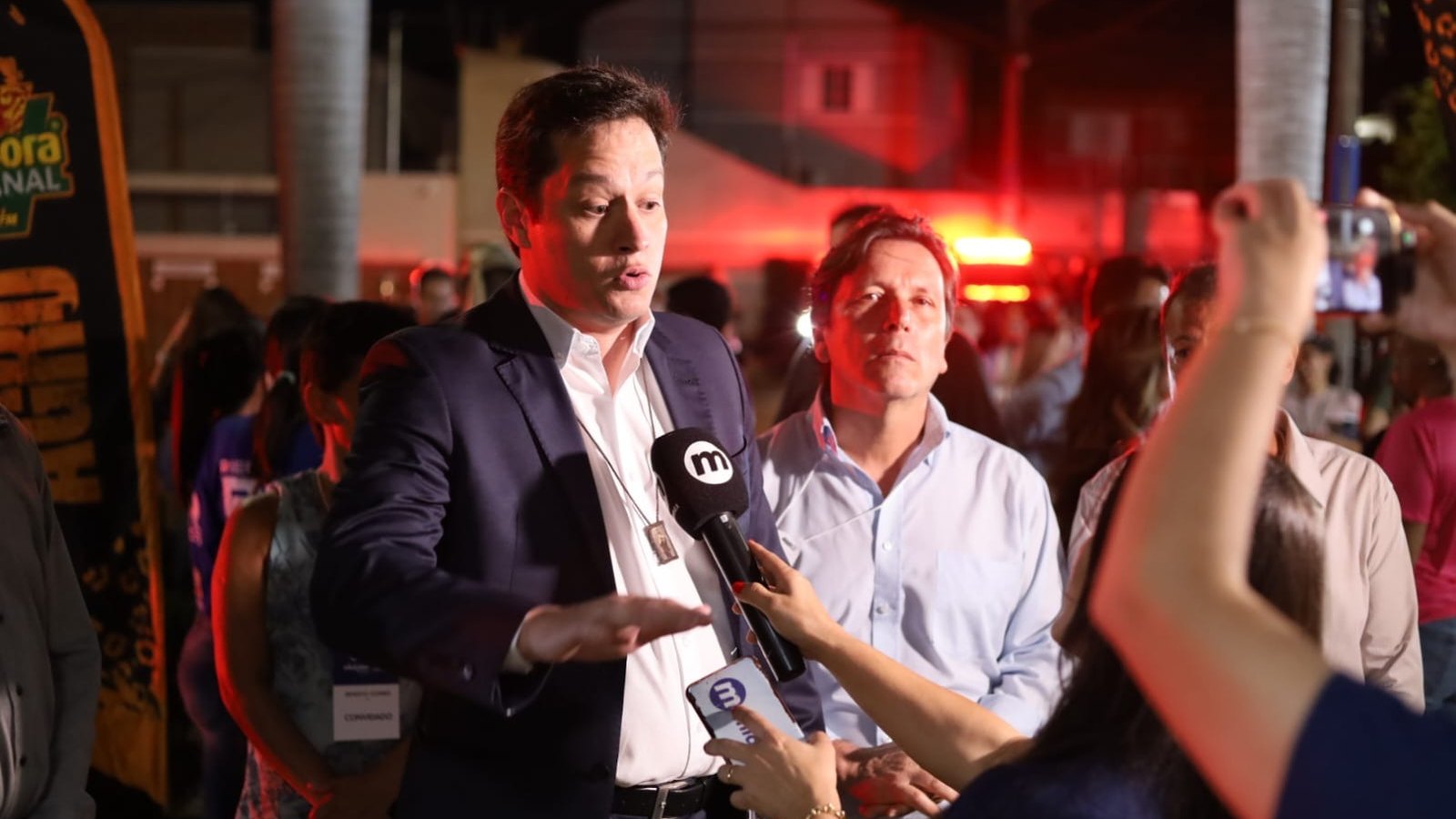 Renato W. Gomes dá entrevista, cercado por repórteres